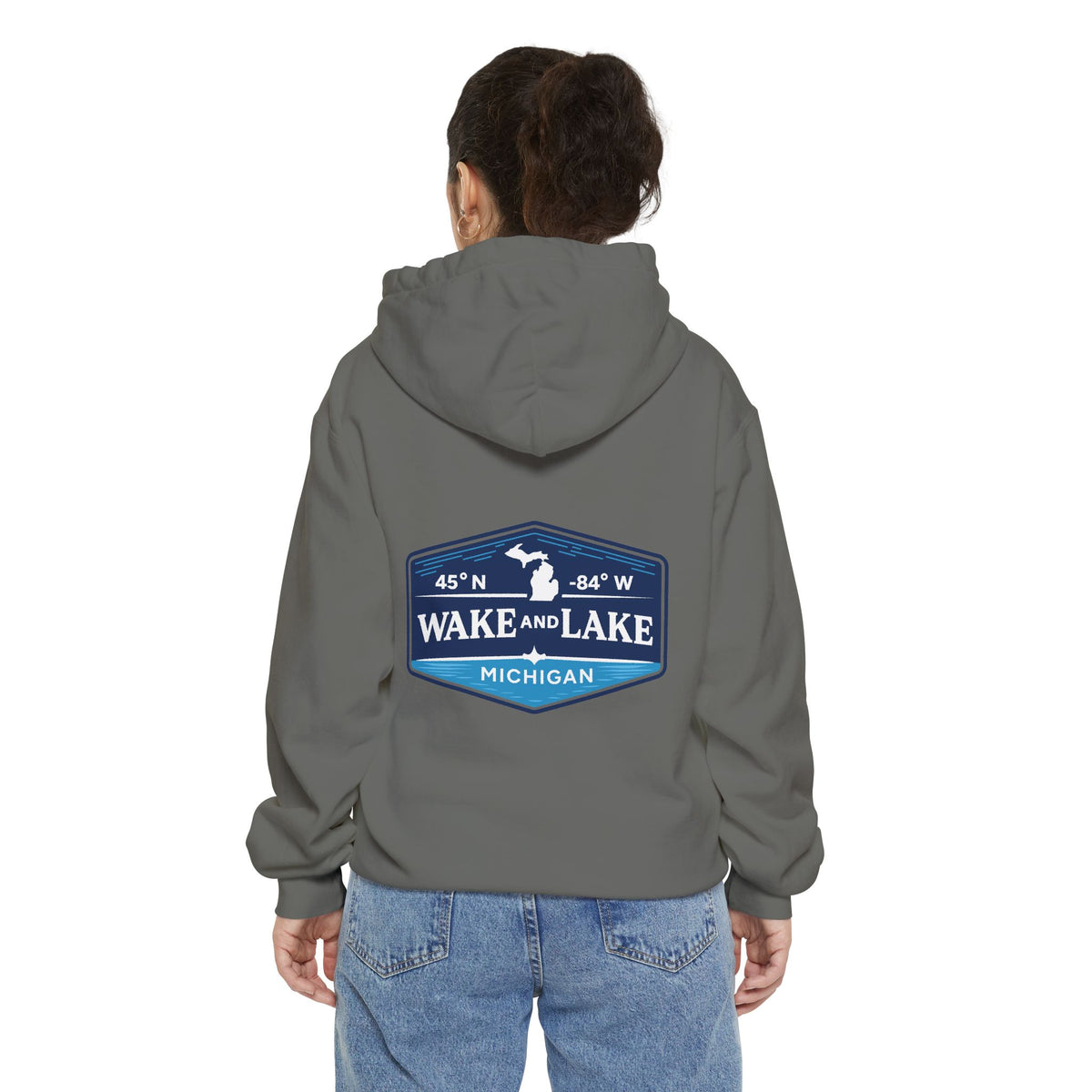 Model wearing the Wake and Lake Michigan Shield Hoodie – Premium in Grey, back view showing the 45°N -84°W coordinate badge.