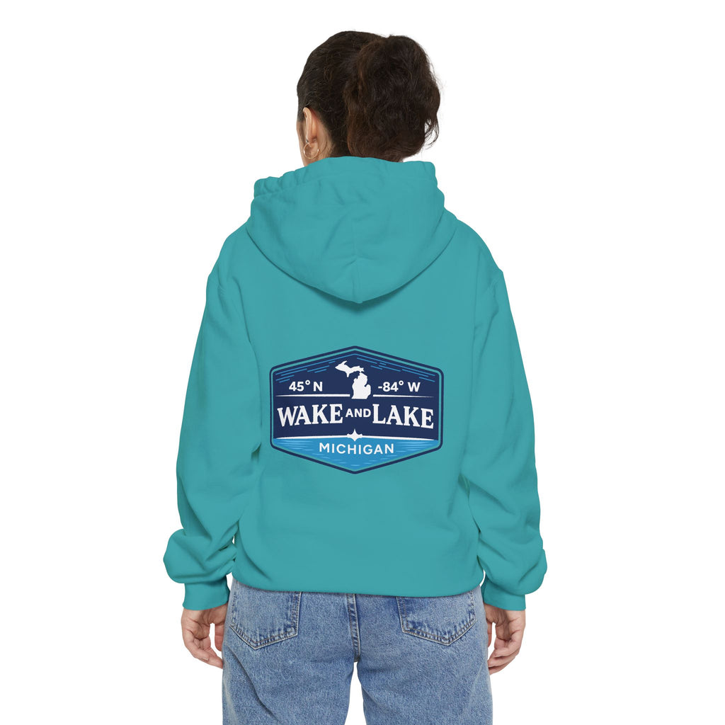 Model wearing the Wake and Lake Michigan Shield Hoodie – Premium in Seafoam, back view showing the 45°N -84°W coordinate badge.