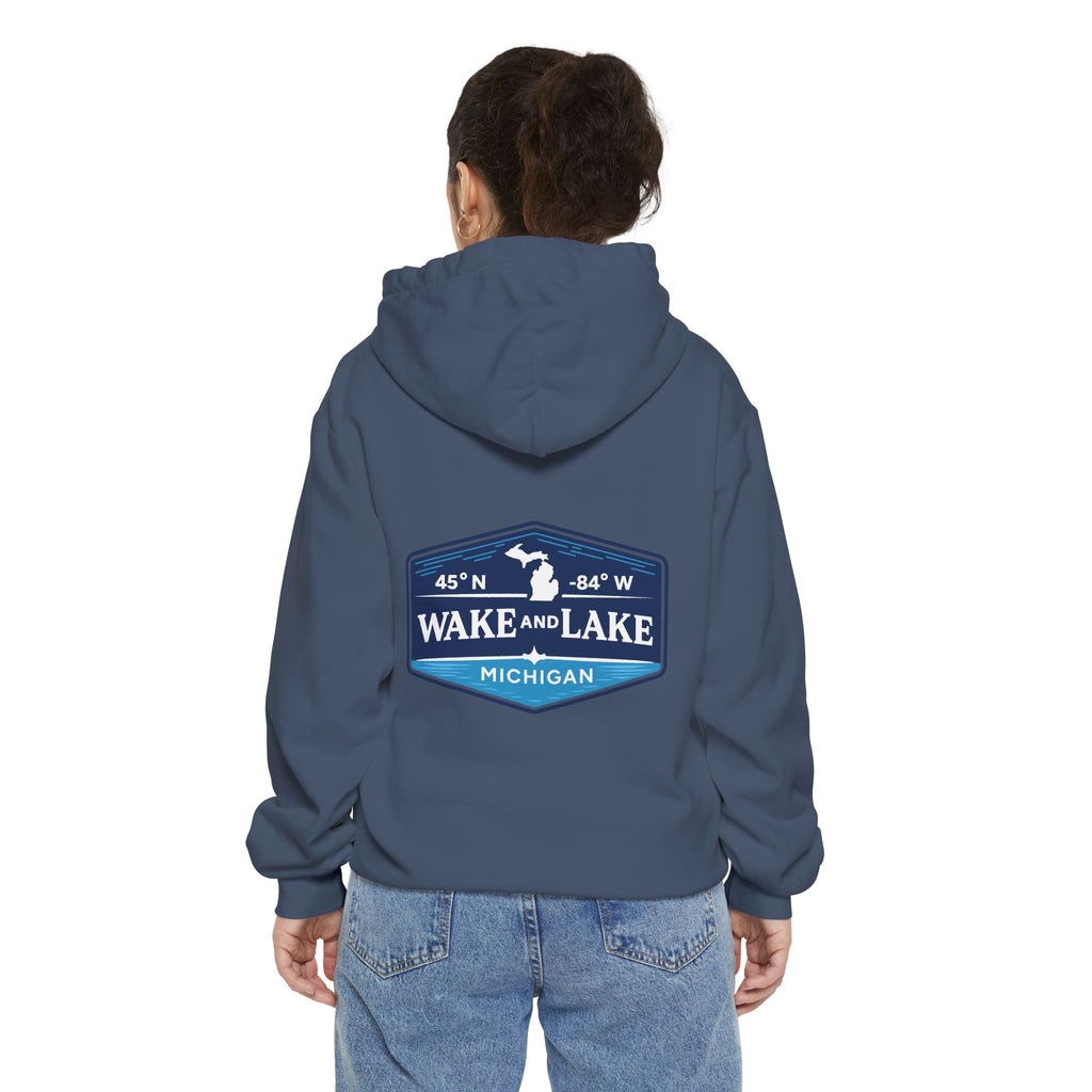 Model wearing the Wake and Lake Michigan Shield Hoodie – Premium in Denim, back view showing the 45°N -84°W coordinate badge.