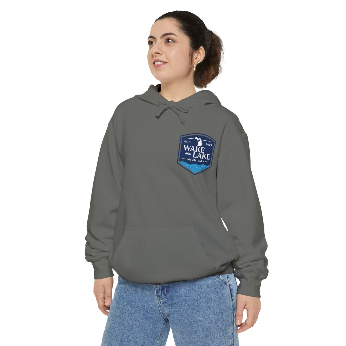 Model wearing the Wake and Lake Michigan Shield Hoodie – Premium in Grey, front view showing the left-chest shield badge.