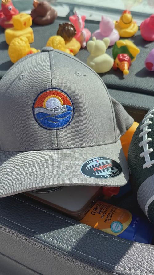 Circle Crest FlexFit Hat on the boat — three colorways, worn on the water, and the FlexFit stretch band